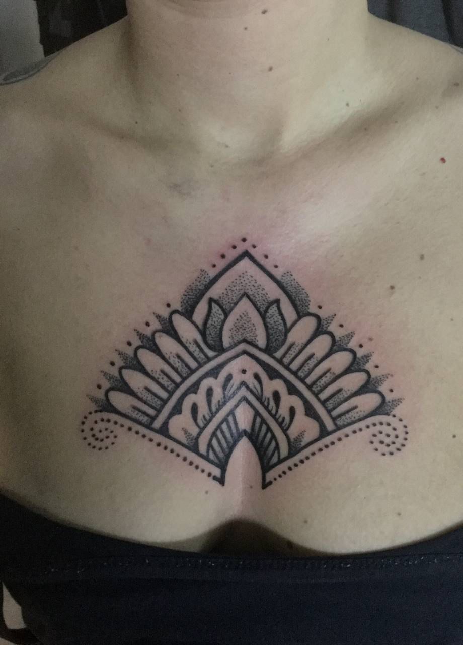 Eine Frau hat ein schwarz-weißes Tattoo auf ihrer Brust.