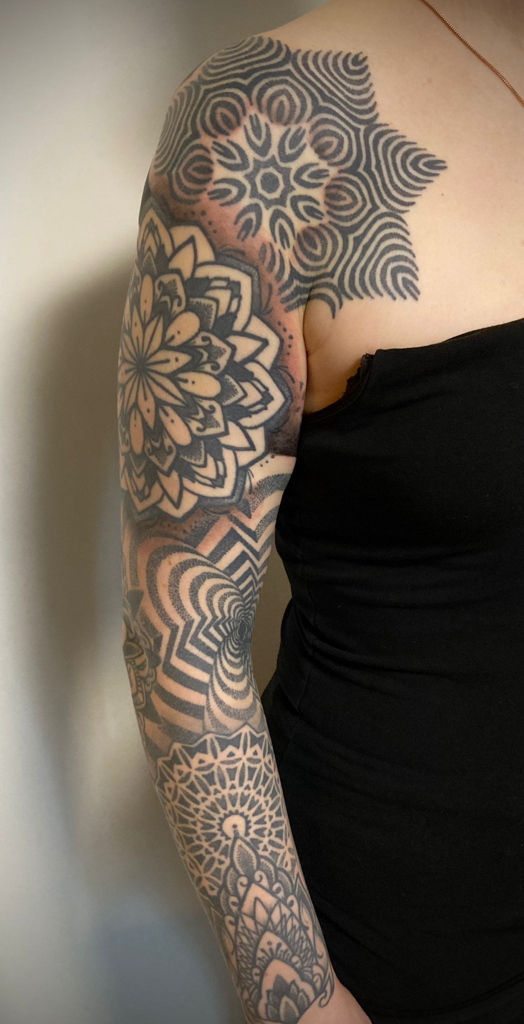 Eine Frau hat eine Tätowierung auf ihrem Arm und ihrer Schulter.