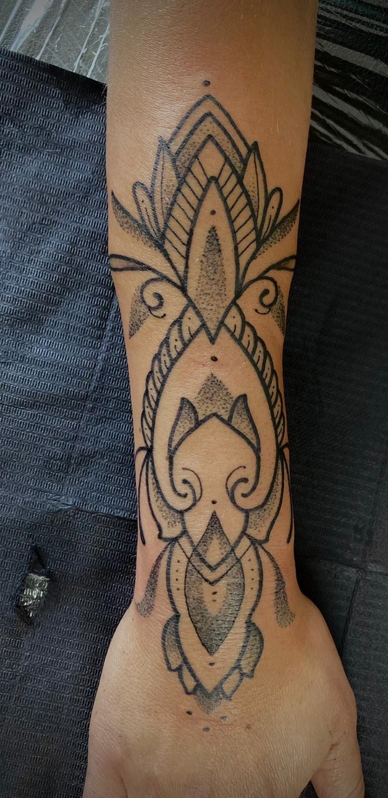 Eine Nahaufnahme des Handgelenks einer Person mit einer Tätowierung darauf.