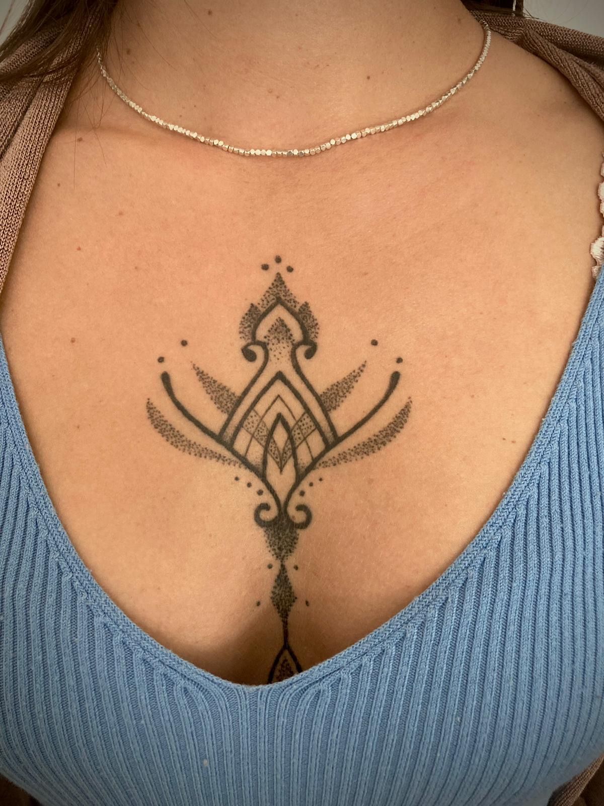 Eine Nahaufnahme der Brust einer Frau mit einem Tattoo darauf