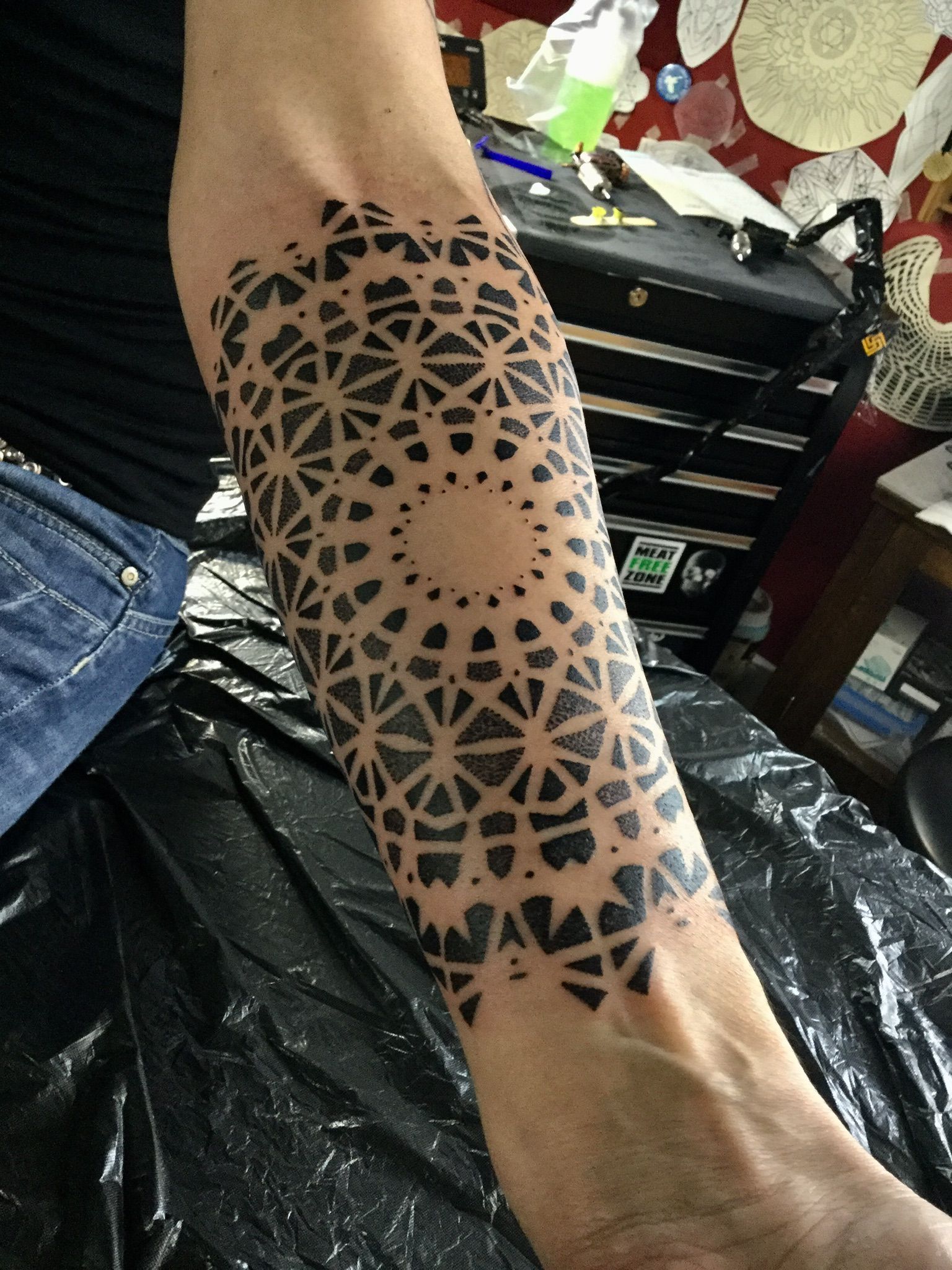 Eine Person hat eine schwarz-weiße Tätowierung auf dem Arm.