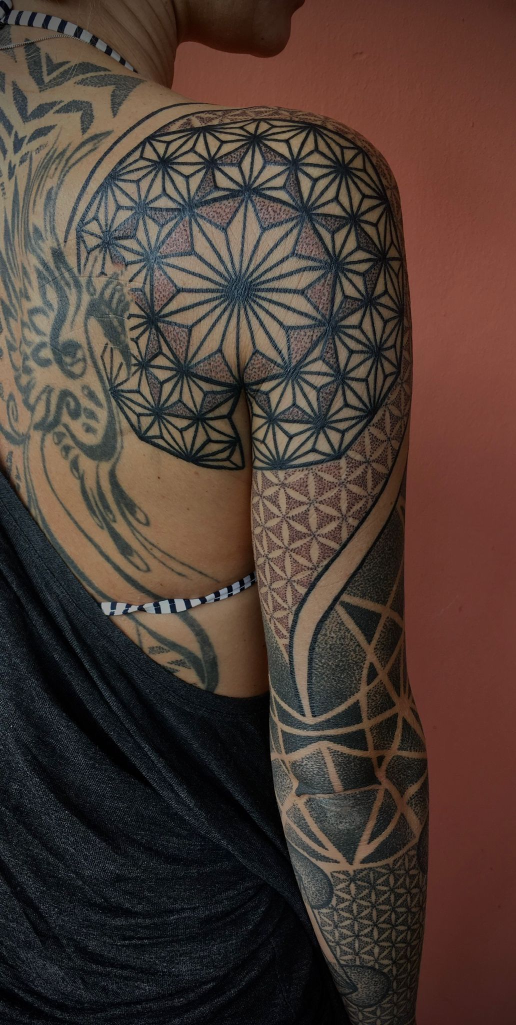 Eine Frau mit vielen Tattoos auf dem Rücken und den Armen.