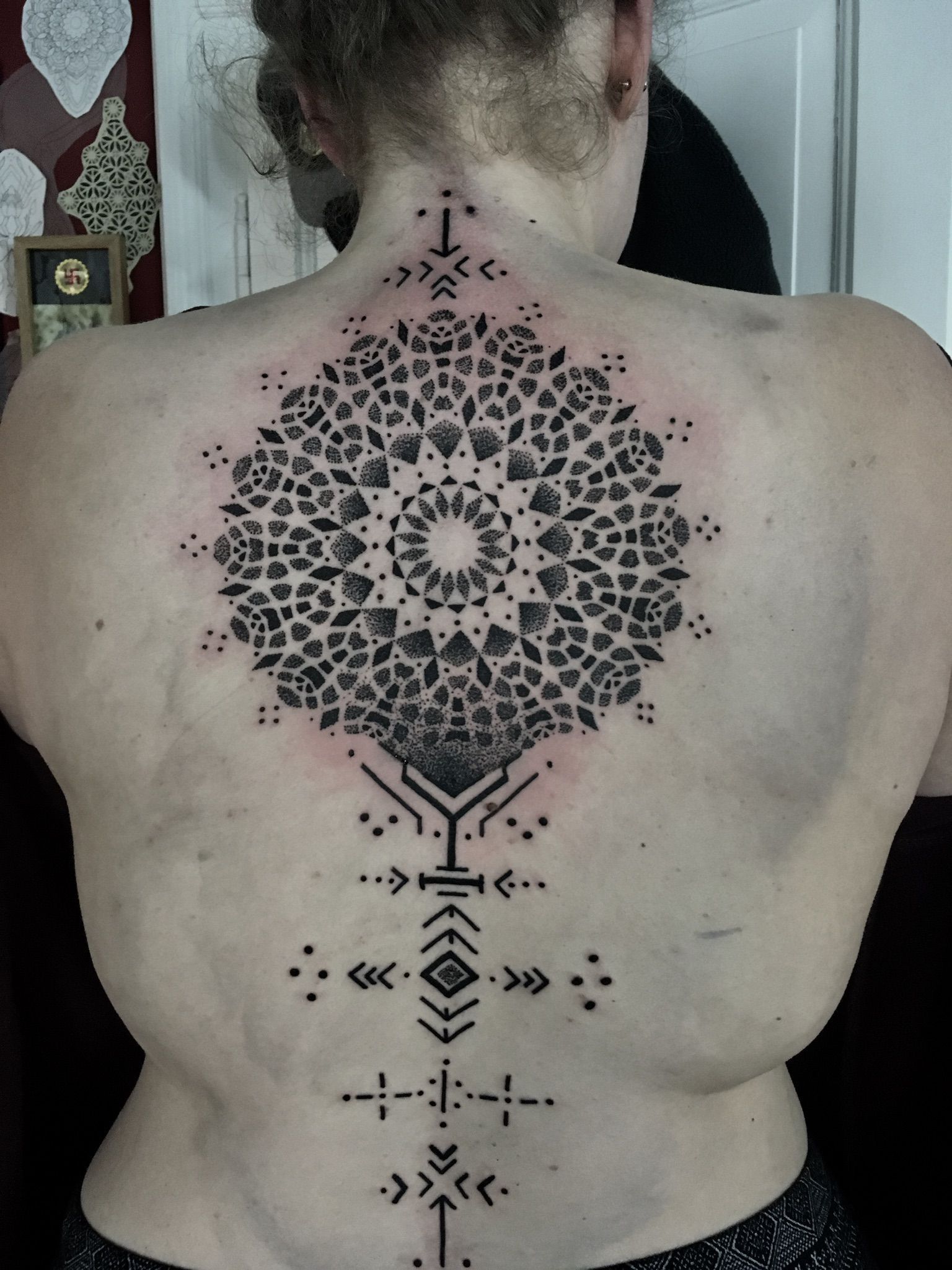 Eine Frau hat ein schwarz-weißes Tattoo auf dem Rücken
