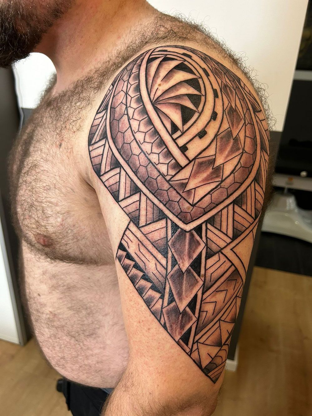 Ein Mann mit einer Tätowierung auf Schulter und Brust.