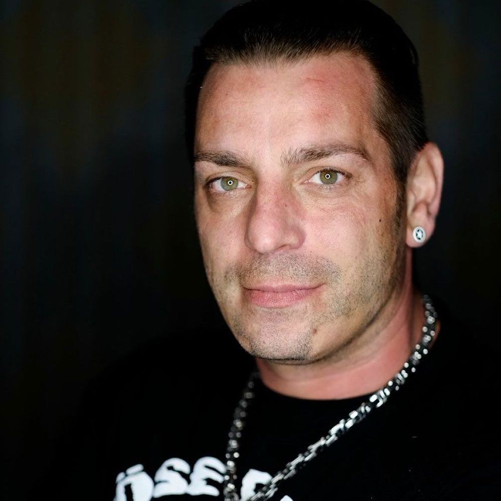 Eine Nahaufnahme eines Mannes, der eine Halskette und Ohrringe trägt