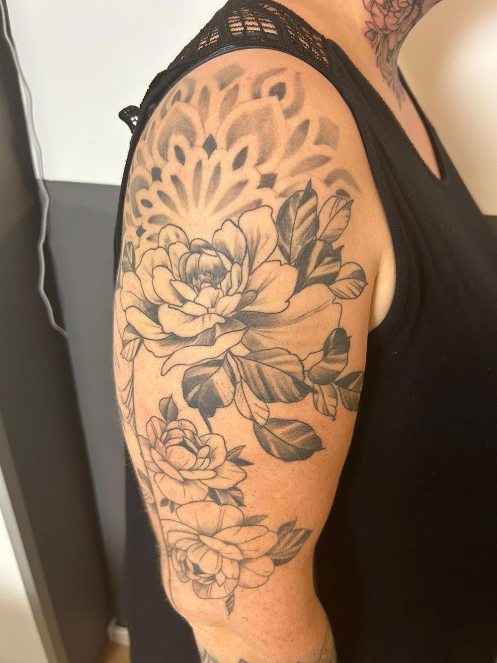 Eine Frau hat eine Blumentätowierung auf ihrem Arm