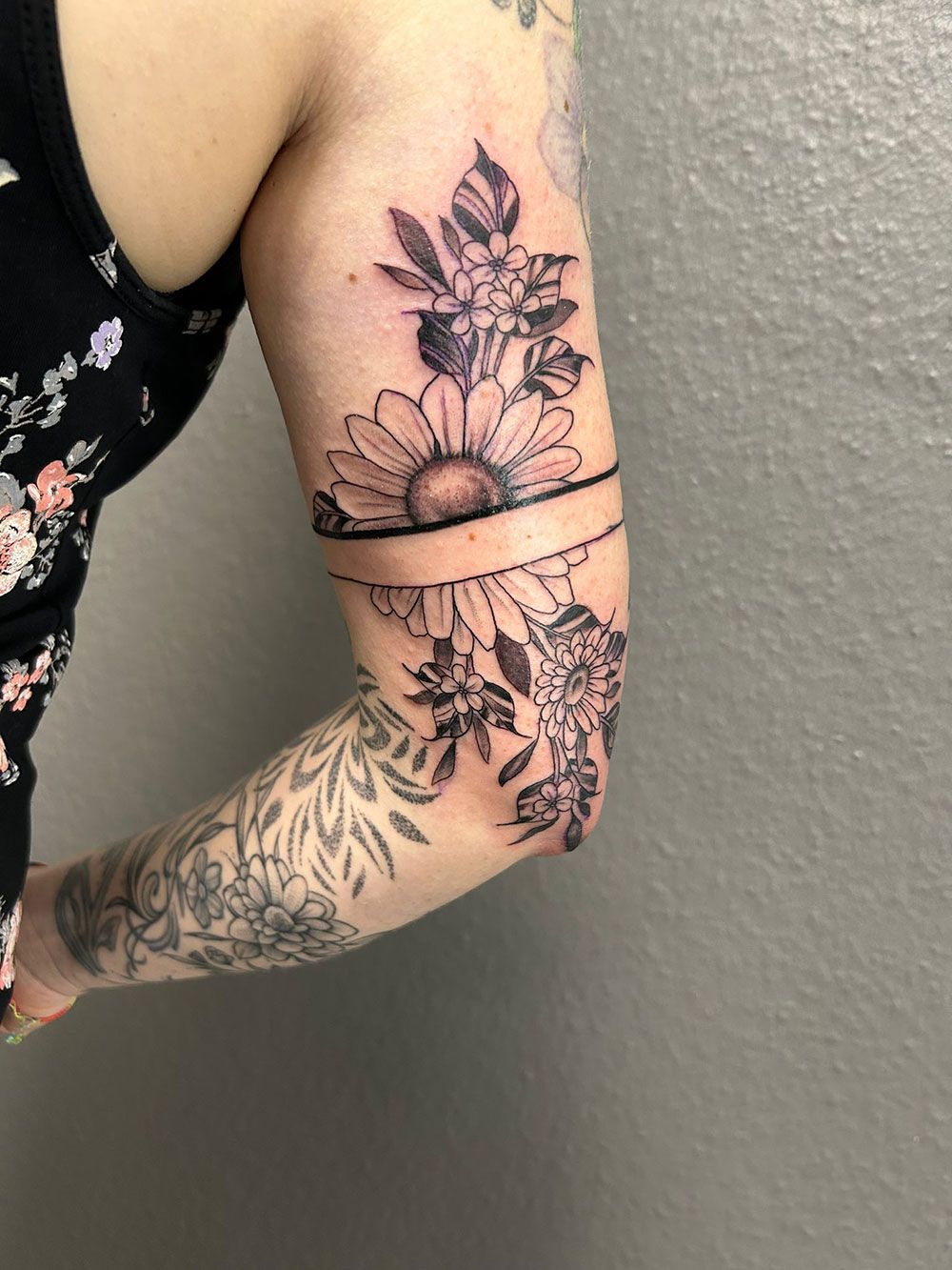 Eine Frau hat eine Blumentätowierung auf ihrem Arm.