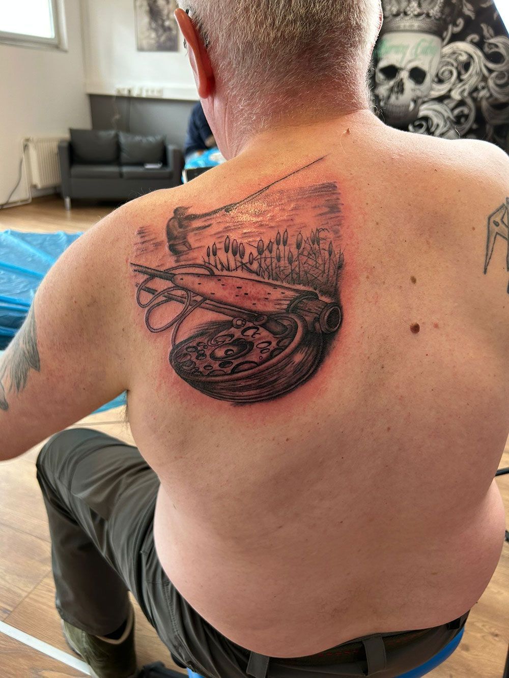 Ein Mann hat eine Kompasstätowierung auf seinem Rücken.