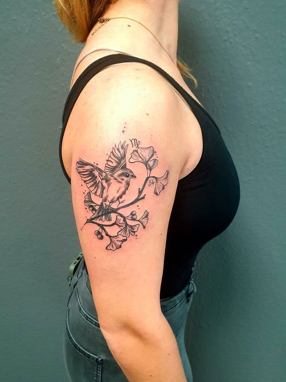 Eine Frau hat eine Vogeltätowierung auf ihrem Arm.