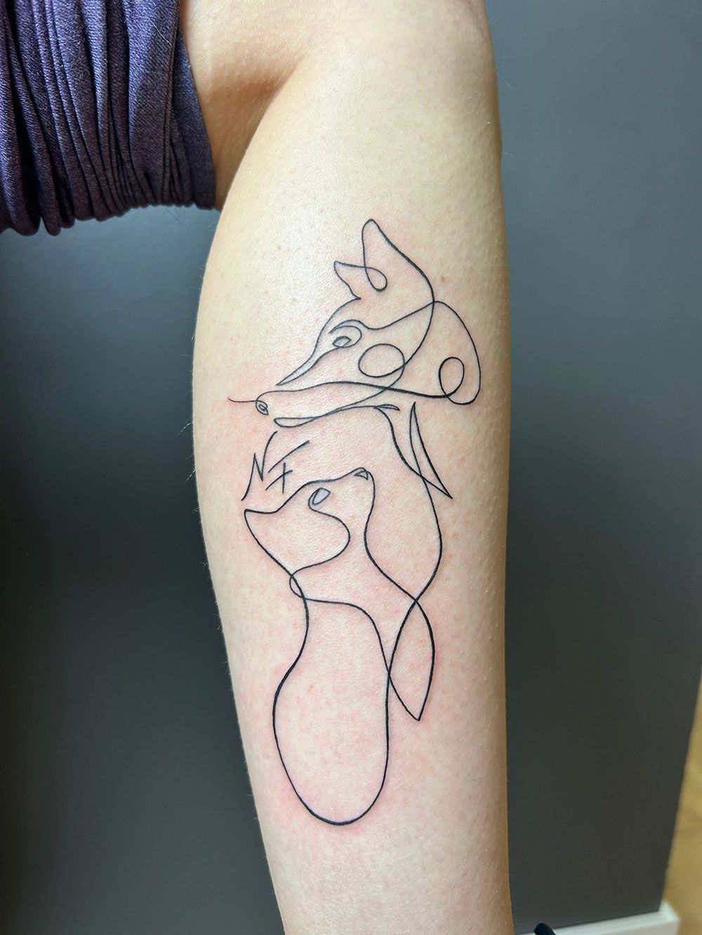 Eine Person hat eine Fuchstätowierung auf ihrem Bein.