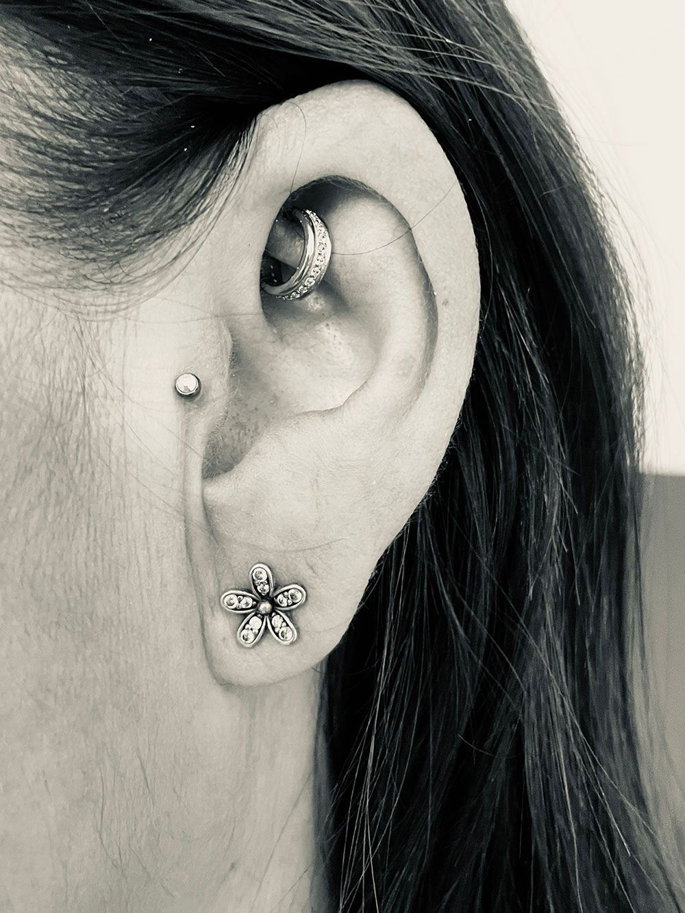 Ein Schwarzweißfoto eines Frauenohrs mit Ohrringen.