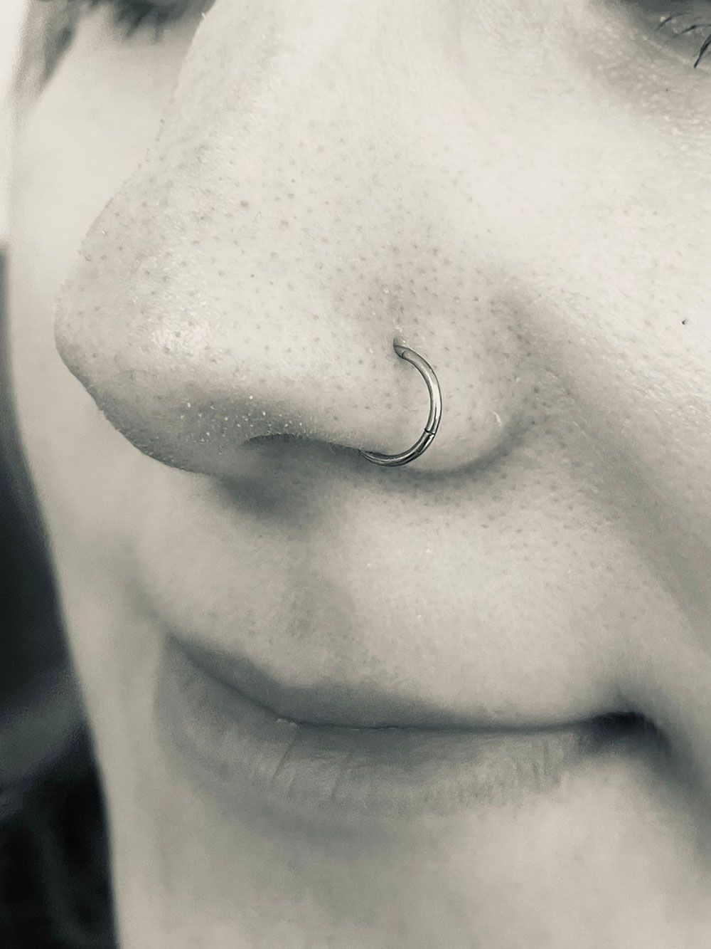 Eine Nahaufnahme der Nase einer Frau mit einem Nasenring.