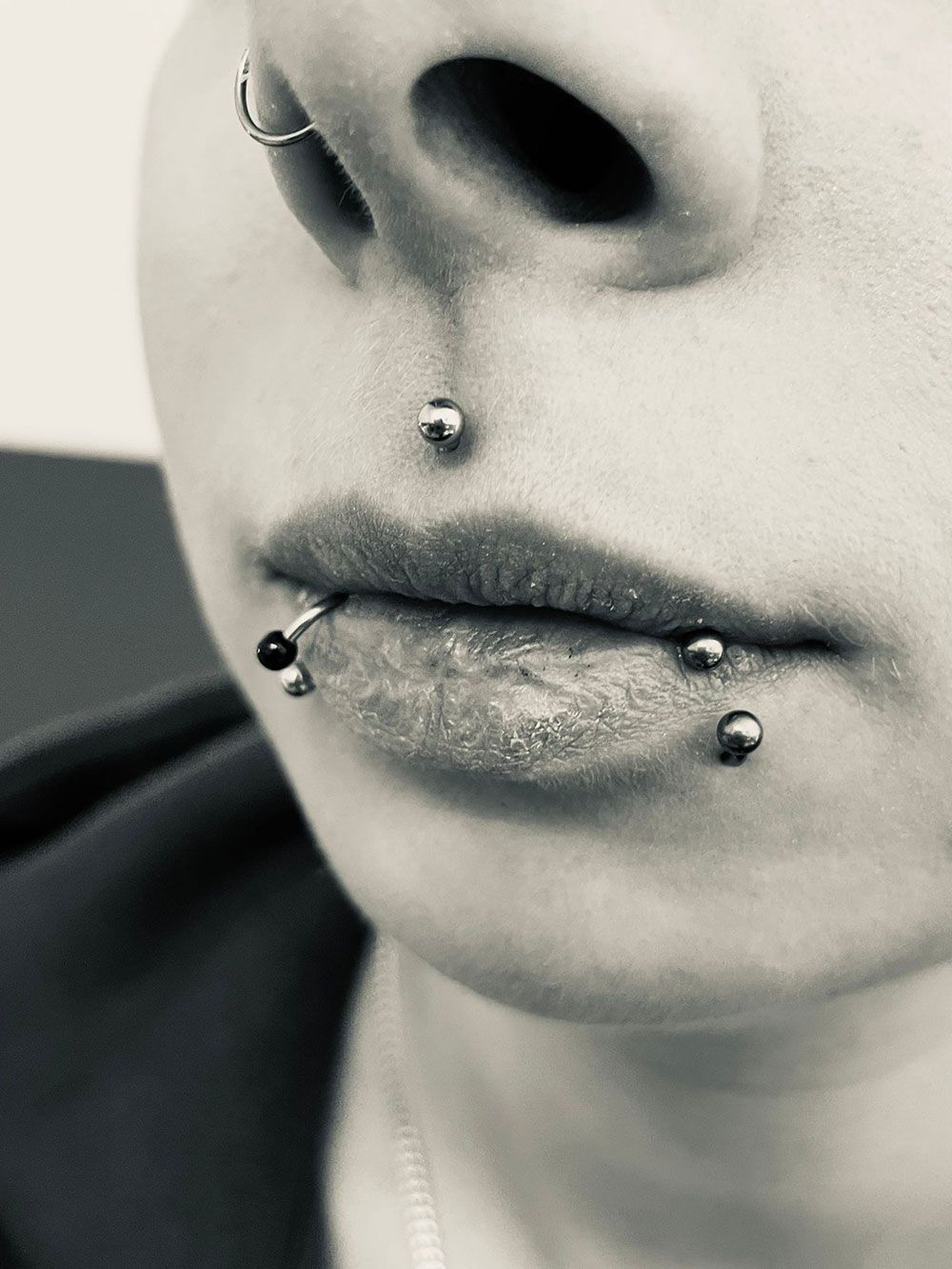 Eine Nahaufnahme des Gesichts einer Frau mit mehreren Piercings.