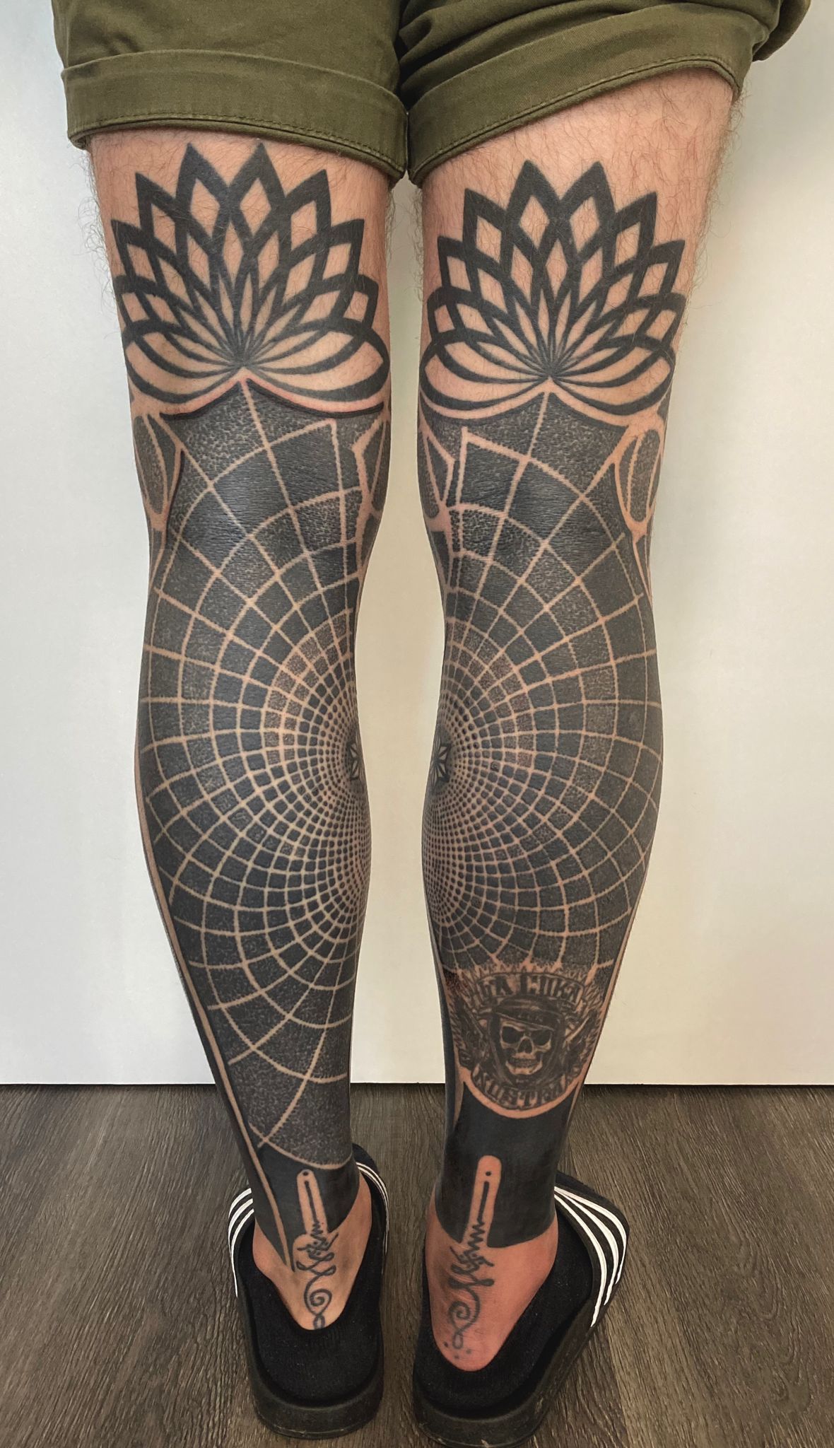 Eine Person mit vielen Tätowierungen auf den Beinen.