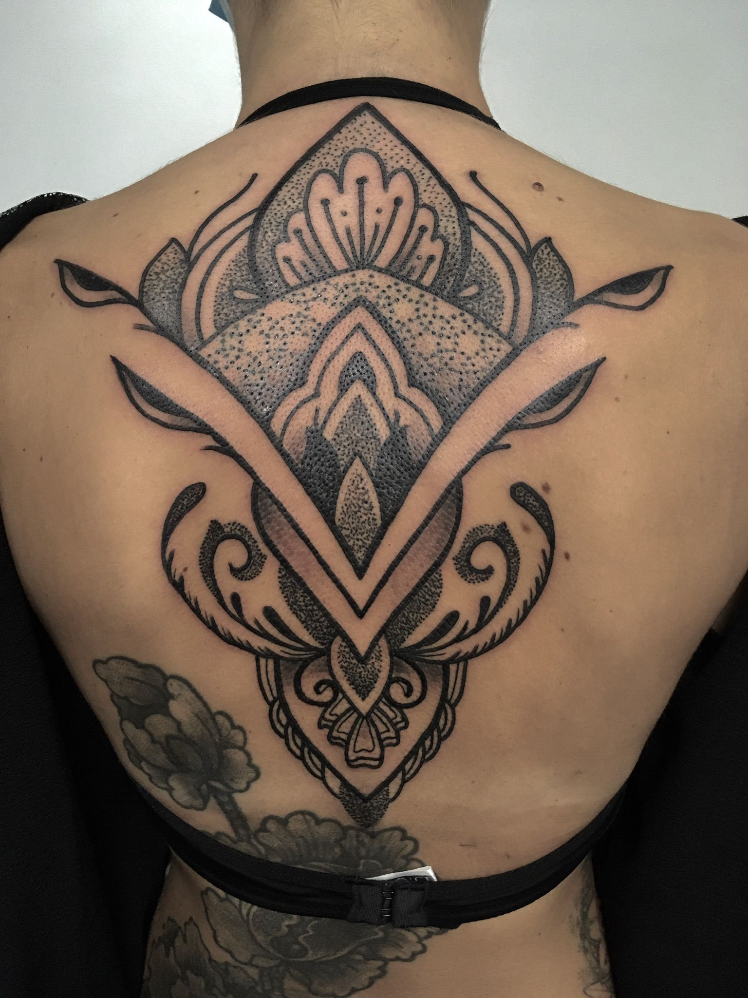 Eine Frau hat ein großes Tattoo auf dem Rücken