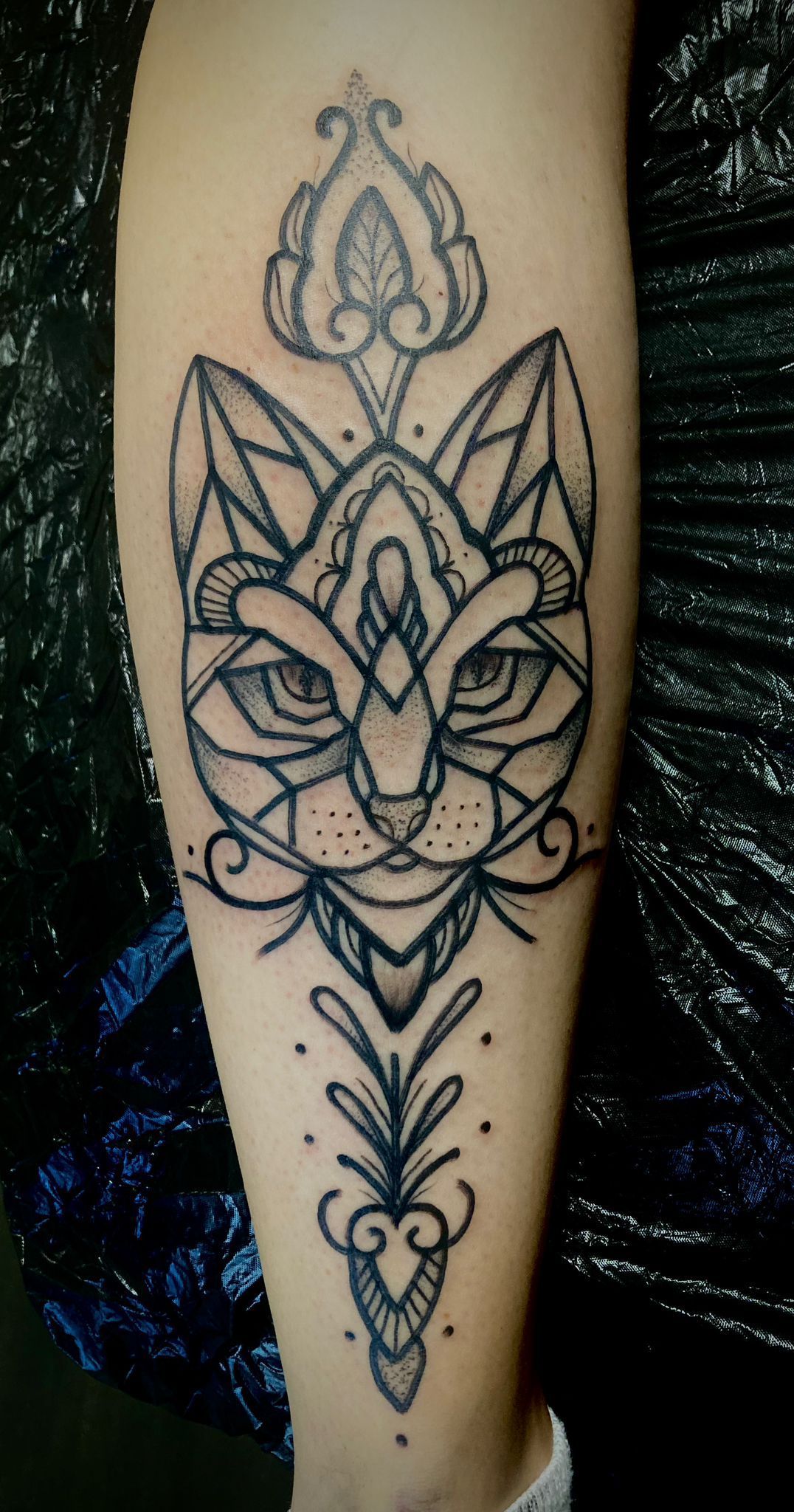 Eine Frau hat eine Tätowierung mit einem Katzenkopf auf ihrem Bein.