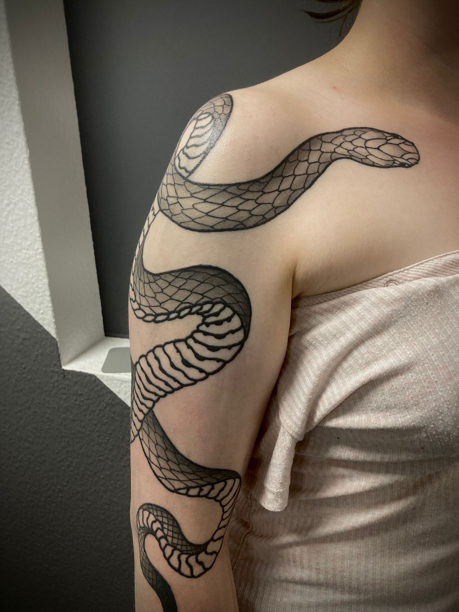 Eine Frau hat eine Schlangentätowierung auf ihrem Arm.