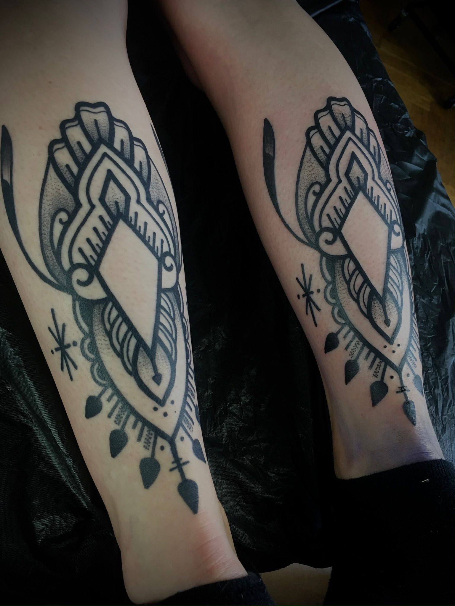 Eine Person hat zwei Tattoos auf ihrem Unterschenkel