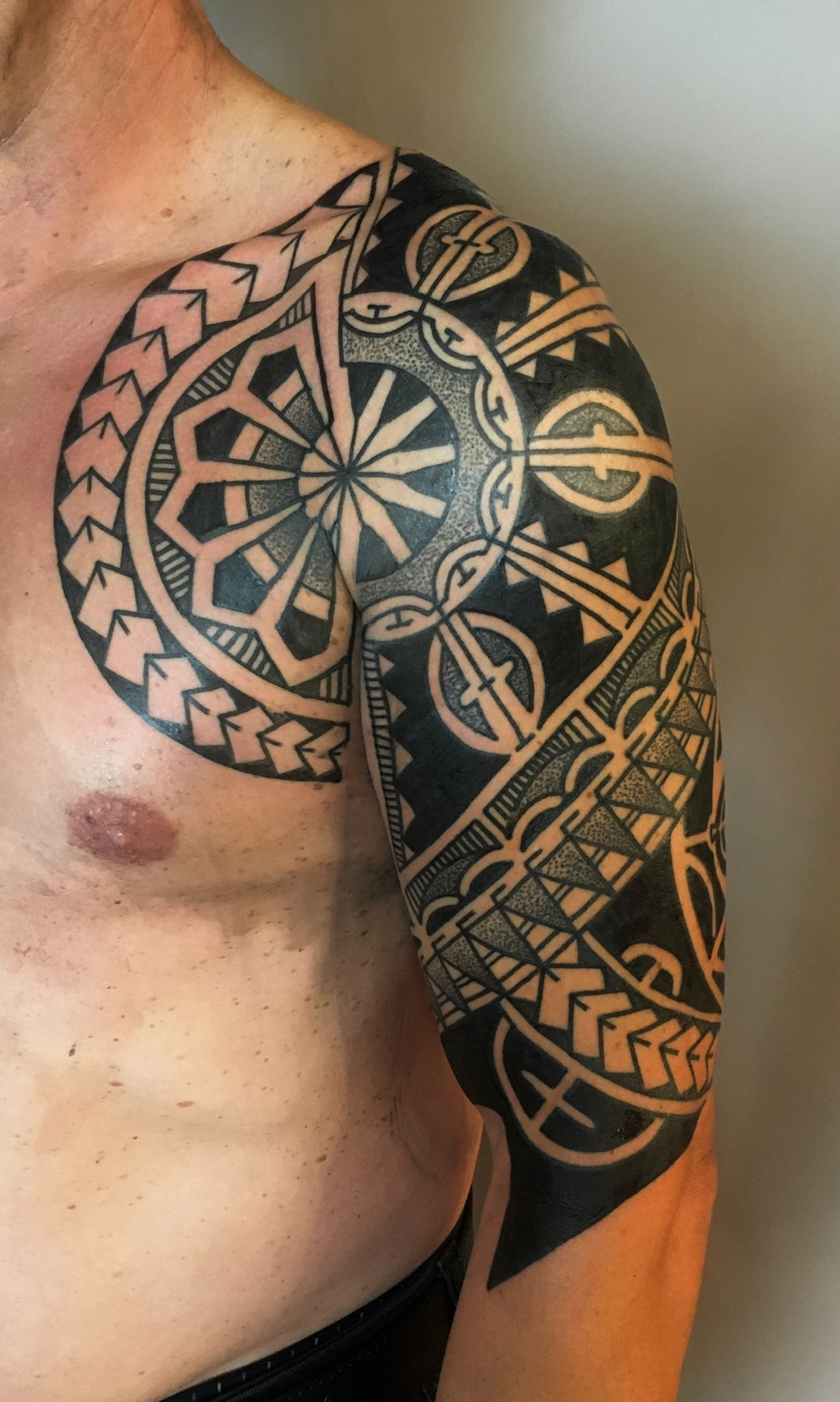 Ein Mann mit einer Tätowierung auf Brust und Schulter.