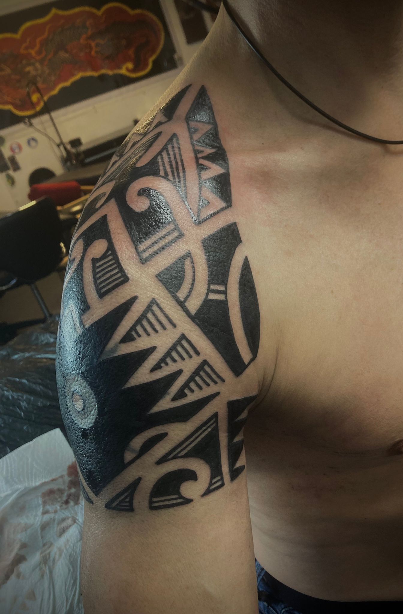 Ein Mann hat ein Stammestattoo auf seiner Schulter
