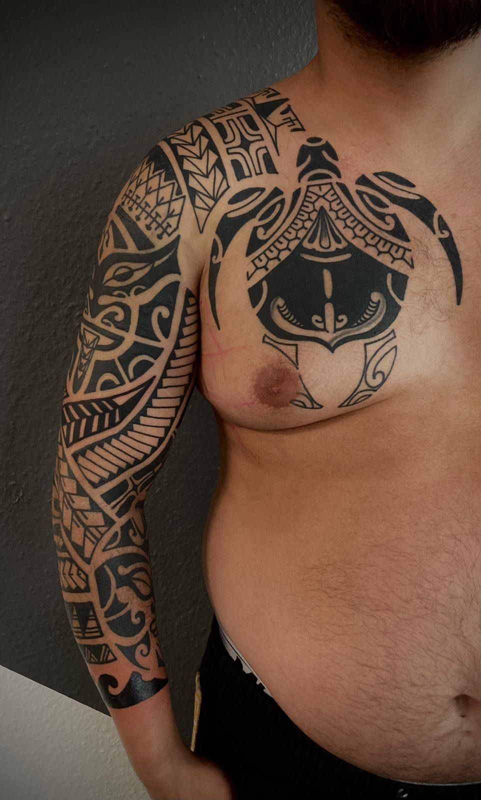 Ein Mann mit einer Tätowierung auf Brust und Arm.