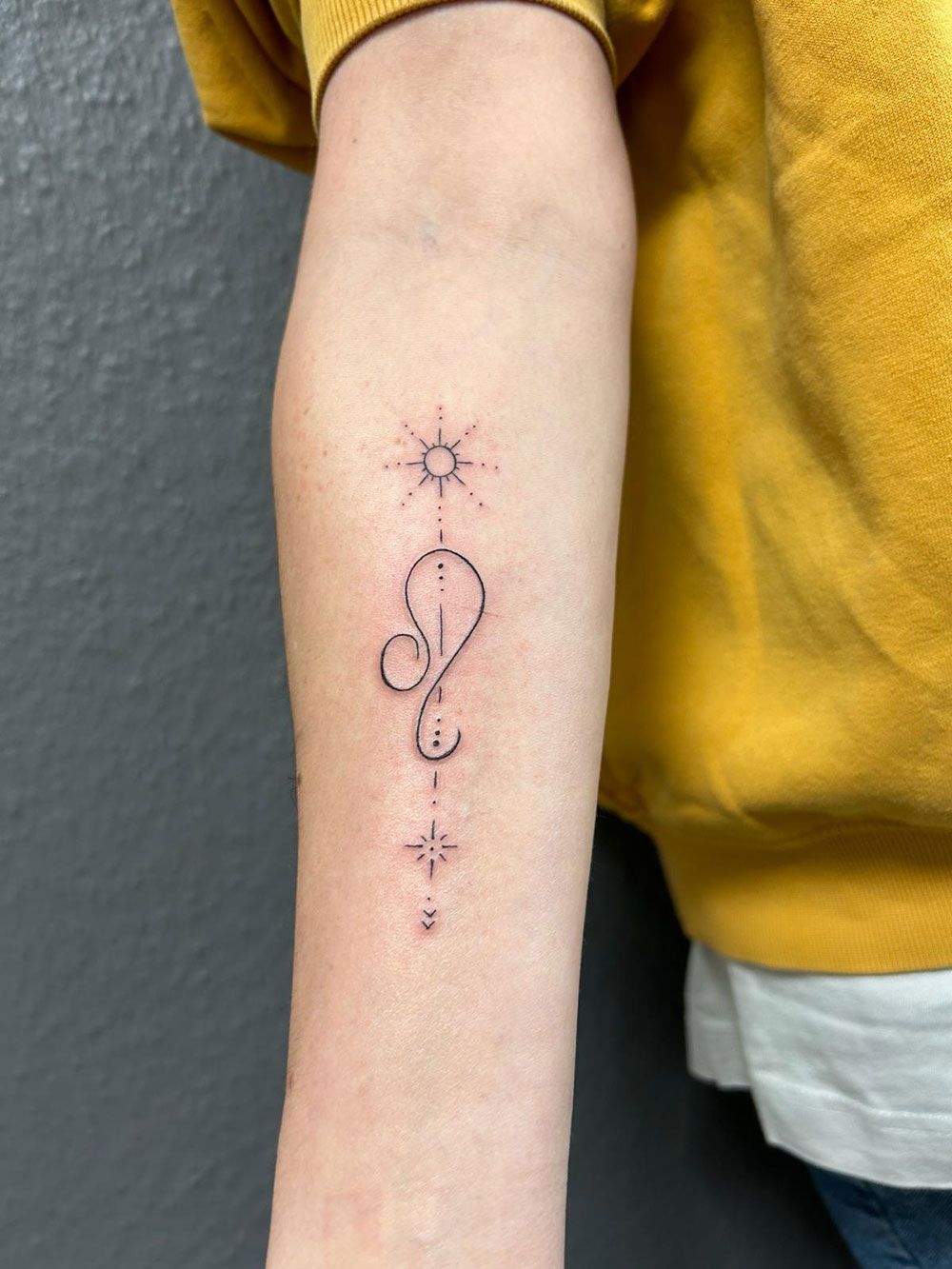 Eine Person mit einer kleinen Tätowierung auf dem Arm.