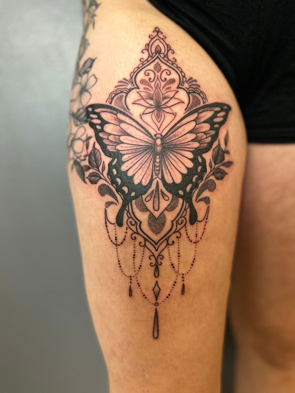 Eine Frau hat ein Schmetterlingstattoo auf ihrem Oberschenkel