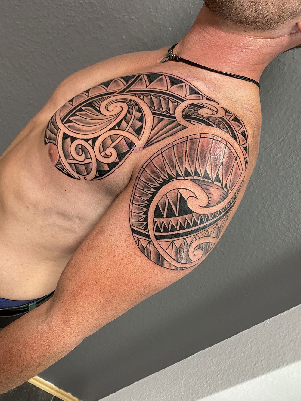 Ein Mann mit einer Tätowierung auf Brust und Schulter.