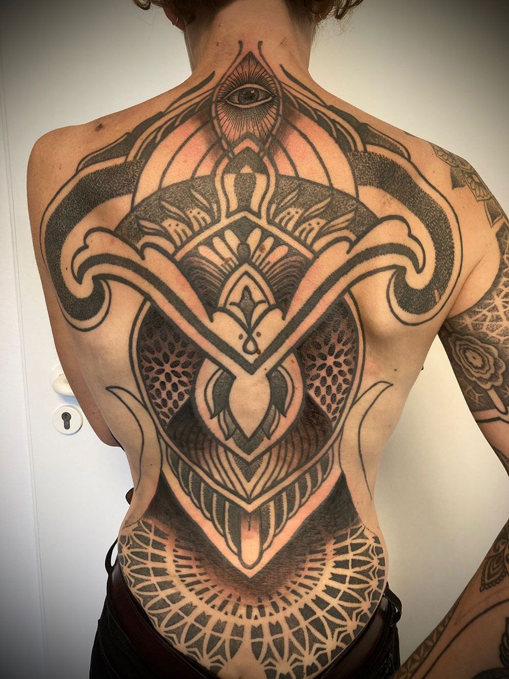 Eine Frau hat eine große Tätowierung auf ihrem Rücken.