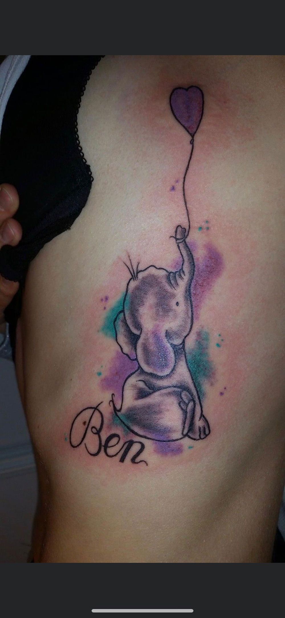 Eine Frau hat eine Tätowierung eines Elefanten, der einen herzförmigen Ballon hält.