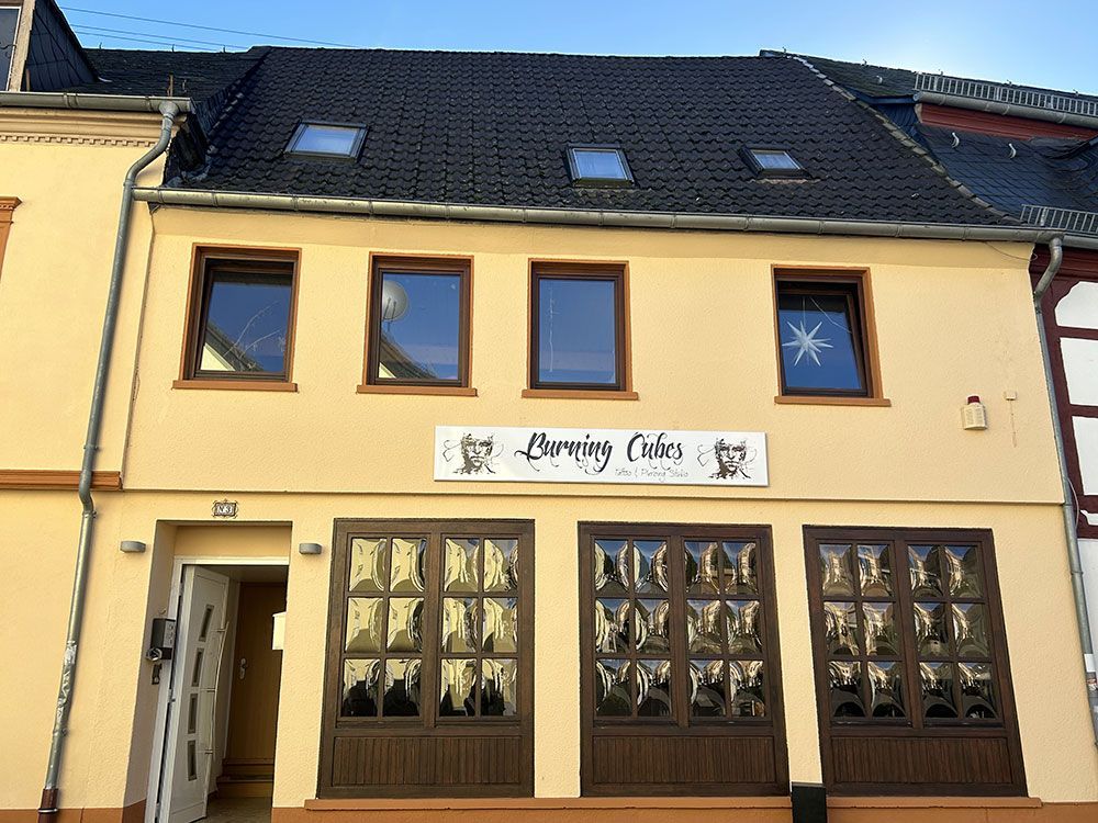 Ein gelbes Gebäude mit einem Schild mit der Aufschrift „Currykuchen“ darauf.