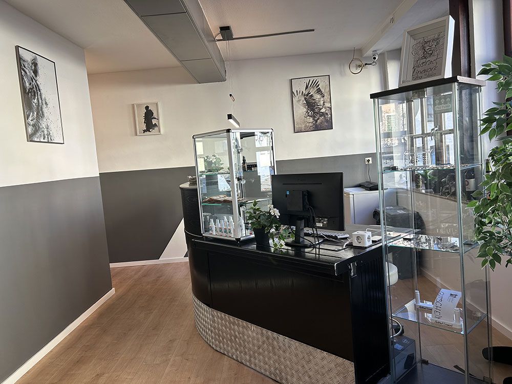 Ein Empfangsbereich mit schwarzem Tresen und Glasvitrine.