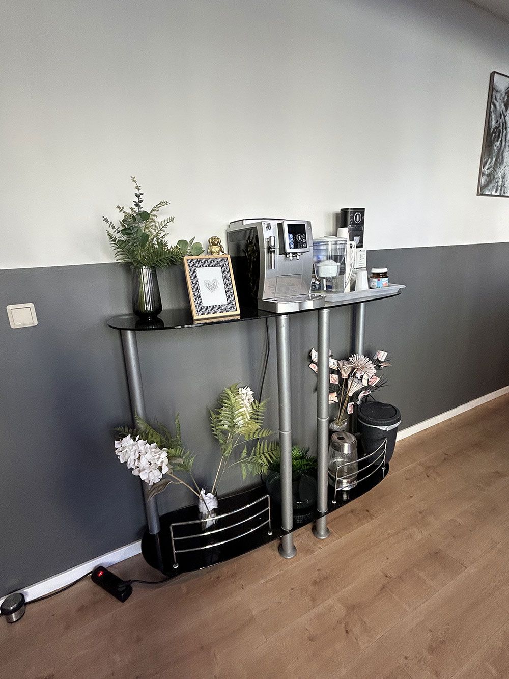 Ein Wohnzimmer mit einem Tisch und einem Bilderrahmen darauf.