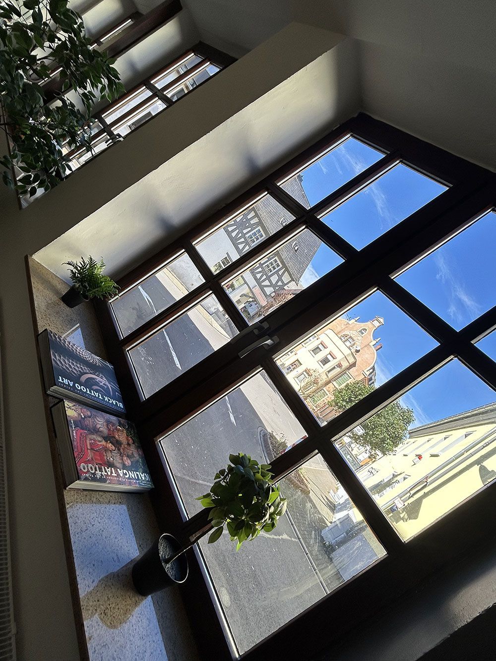 Blick nach oben zu einem Fenster, in dem sich ein Gebäude spiegelt