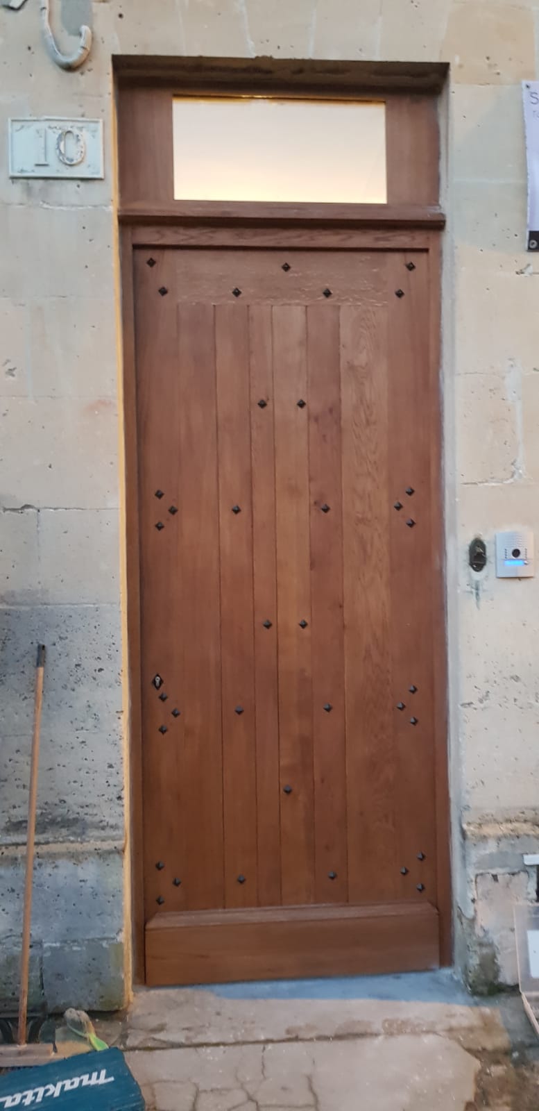 Grande porte en bois sans ouverture, avec une sonnerie