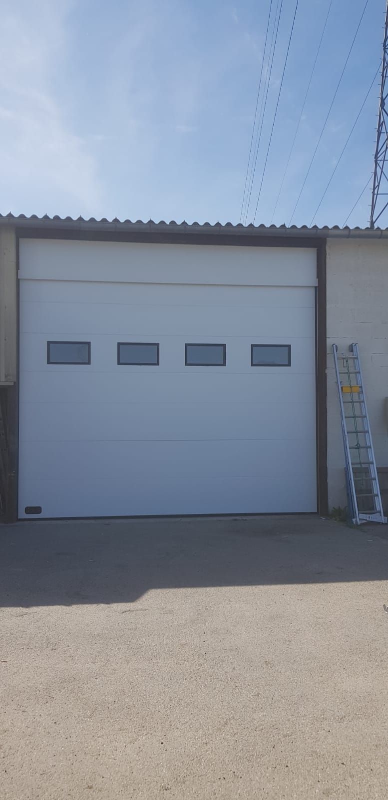 Porte de garage blanche avec 4 petites fenêtres