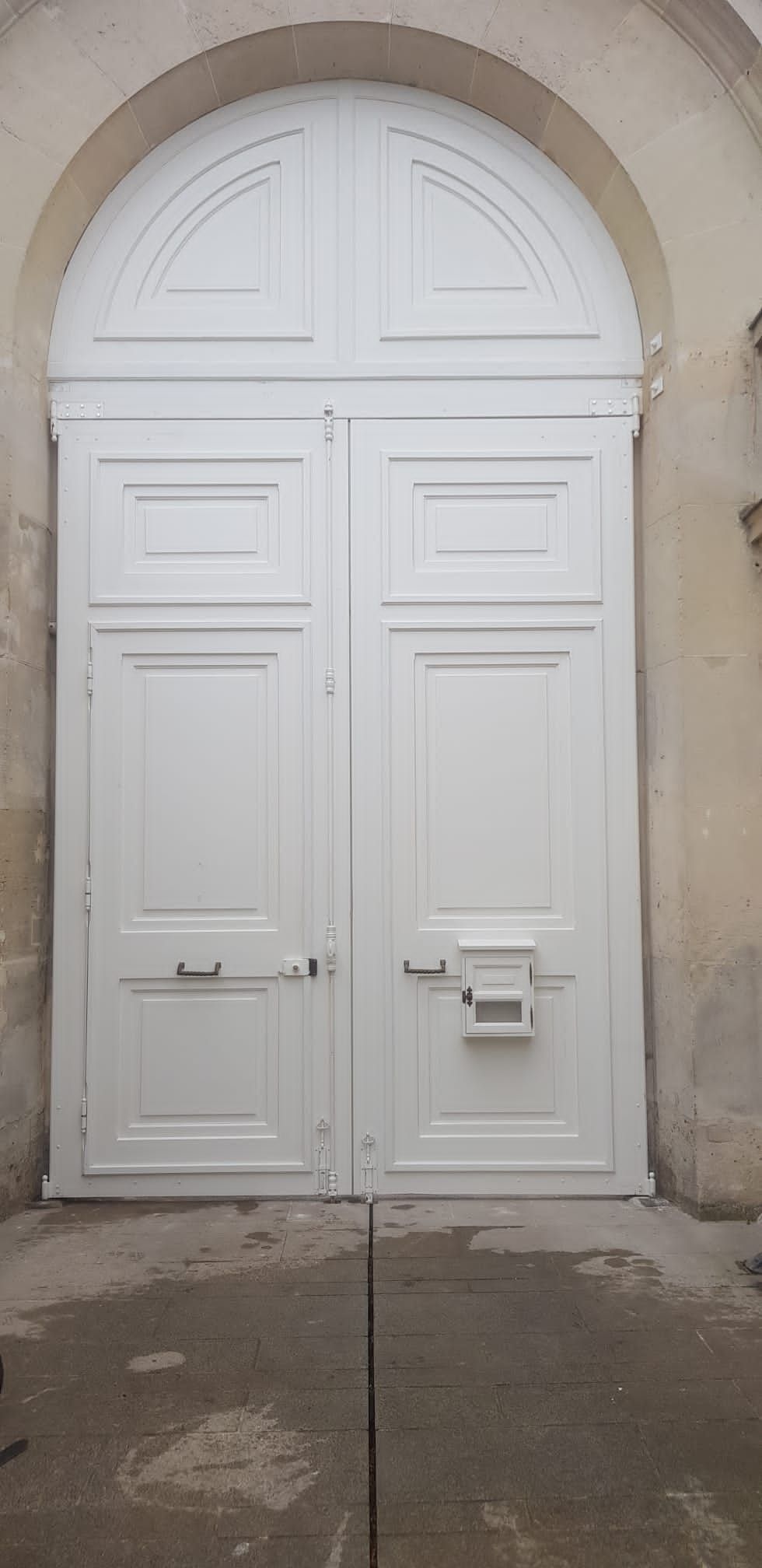 Grande porte blanche avec une boite aux lettres