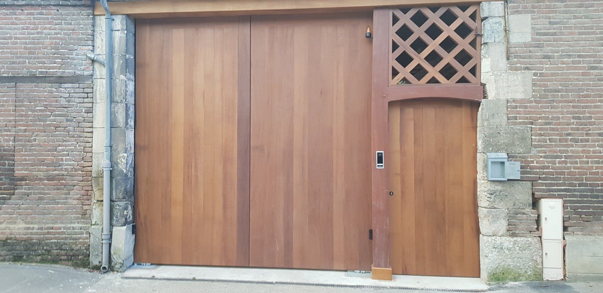 Grande porte de garage en bois avec une porte assortie
