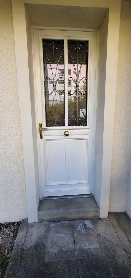 Porte d'entrée blanche avec des poignées dorées