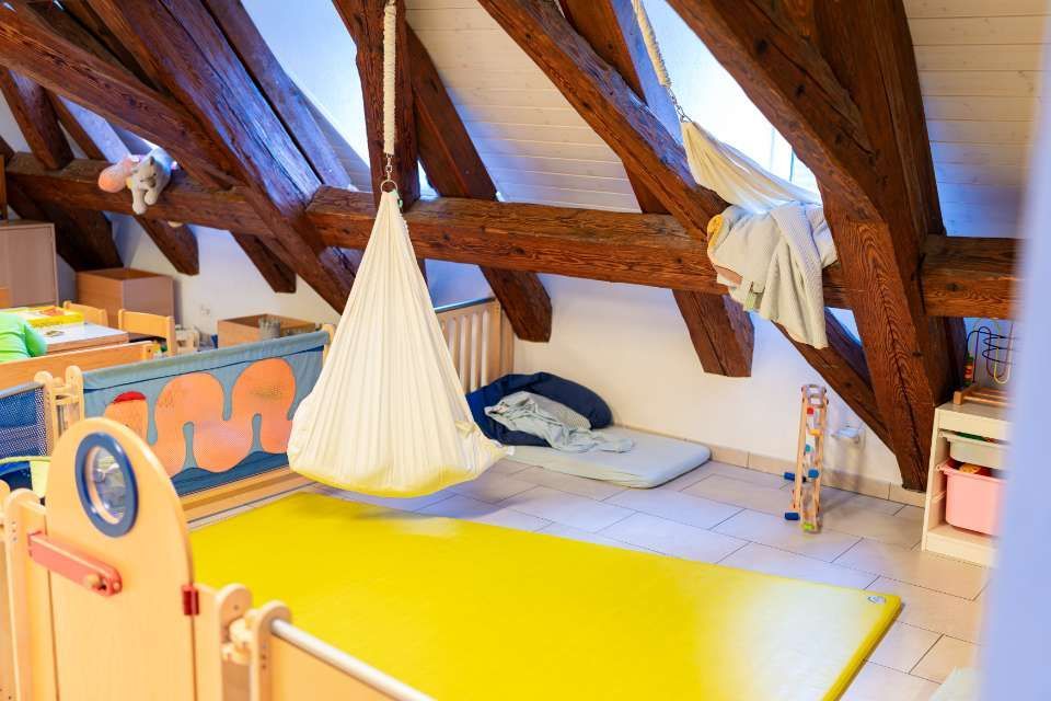 Kinder malen an einem Tisch mit Buntstiften Igelbilder aus.