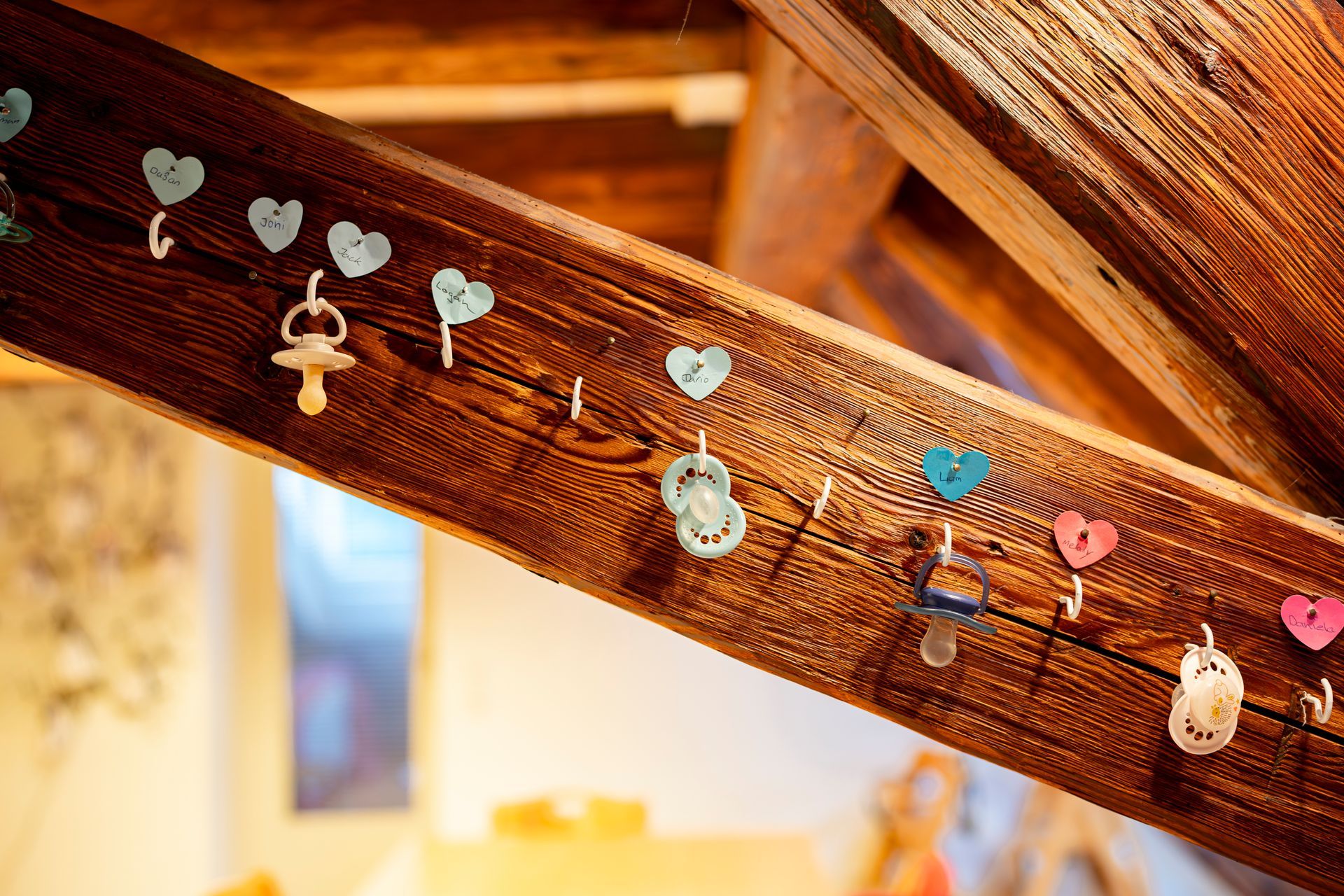 Kinder spielen drinnen mit einem Fussball; einer schiesst, die anderen schauen zu; orangefarbener und gelber Hintergrund.