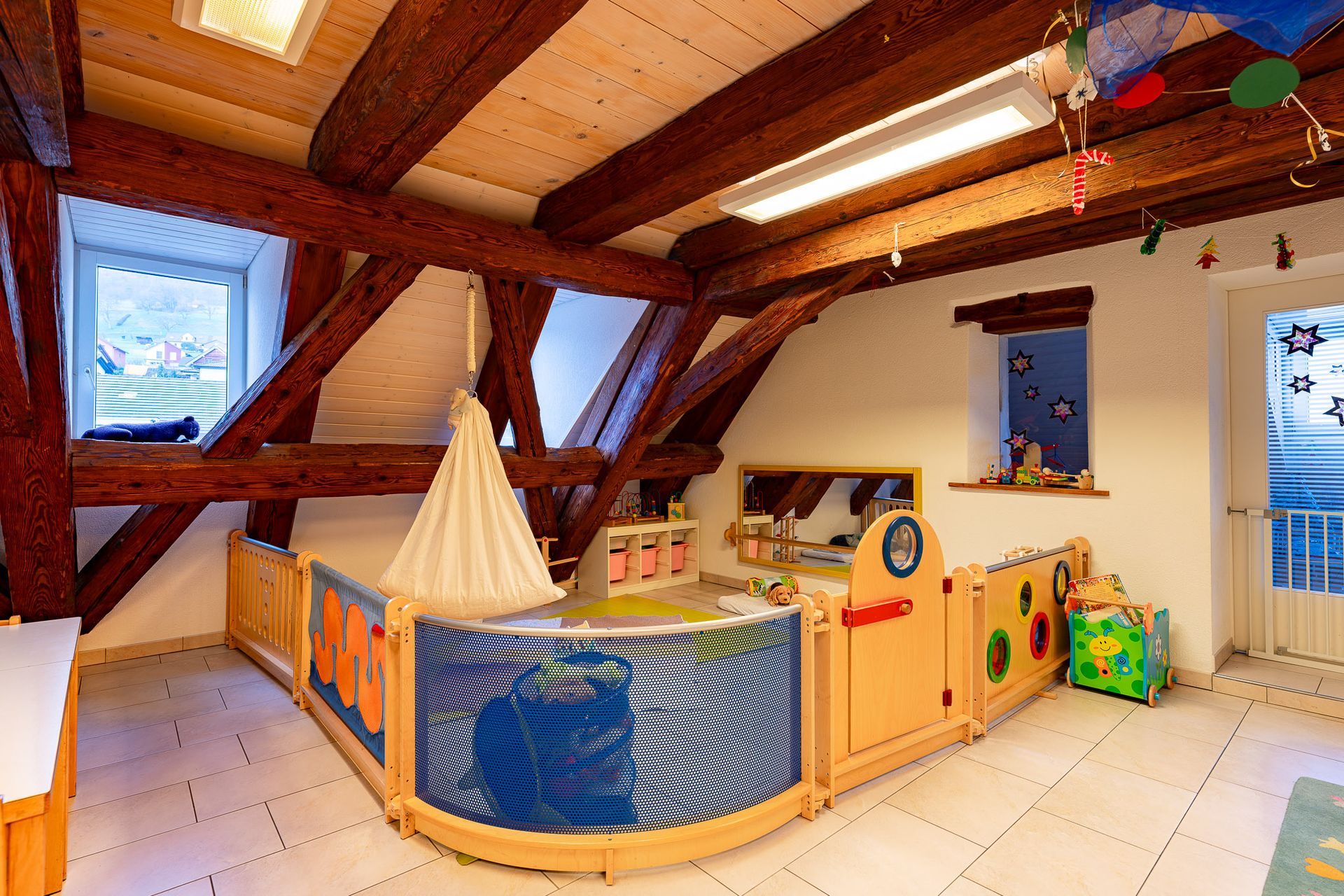 Kinderbetreuungsraum mit Holzbalken und Spielbereich im Bootsstil.