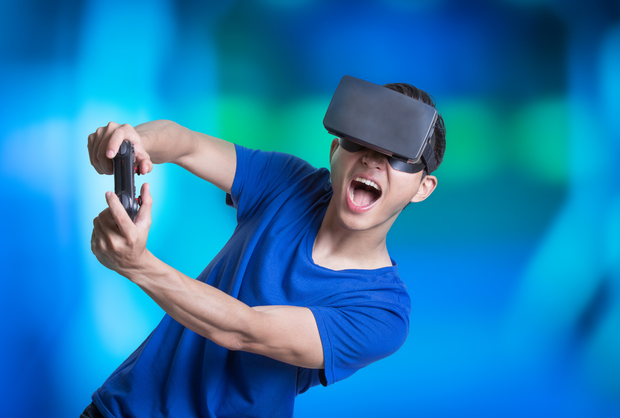 Un uomo che indossa un visore per la realtà virtuale sta giocando a un videogioco