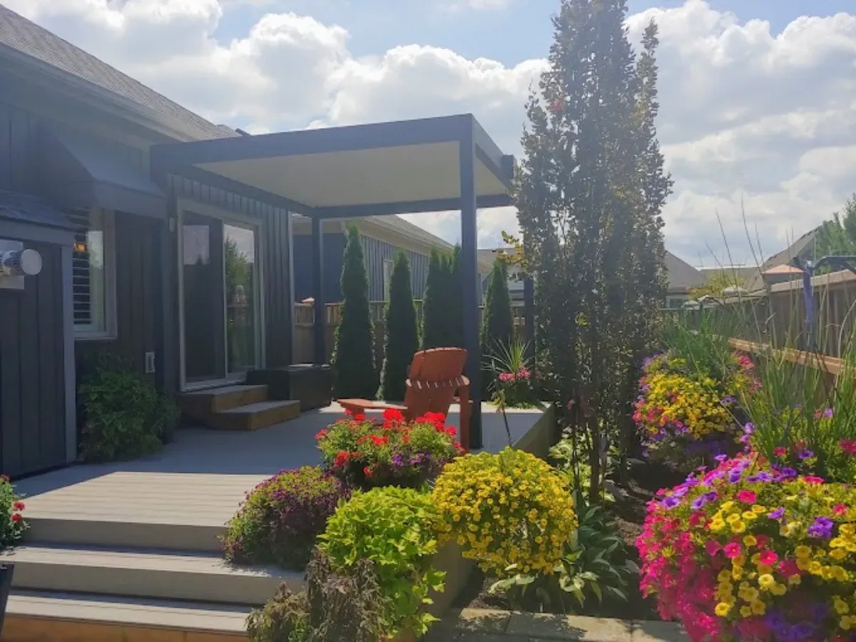 Ein Haus mit einer Veranda und Blumen davor.