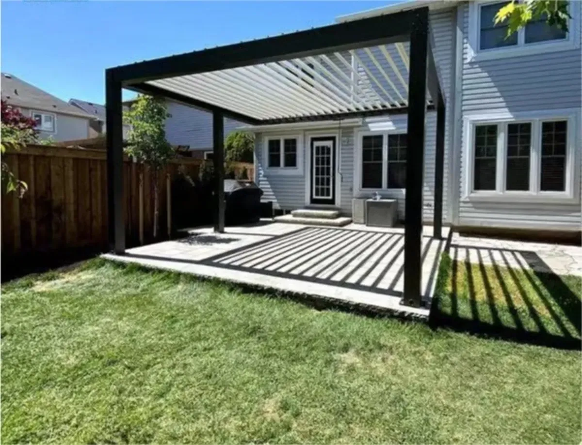 Im Hinterhof eines Hauses steht eine Pergola.