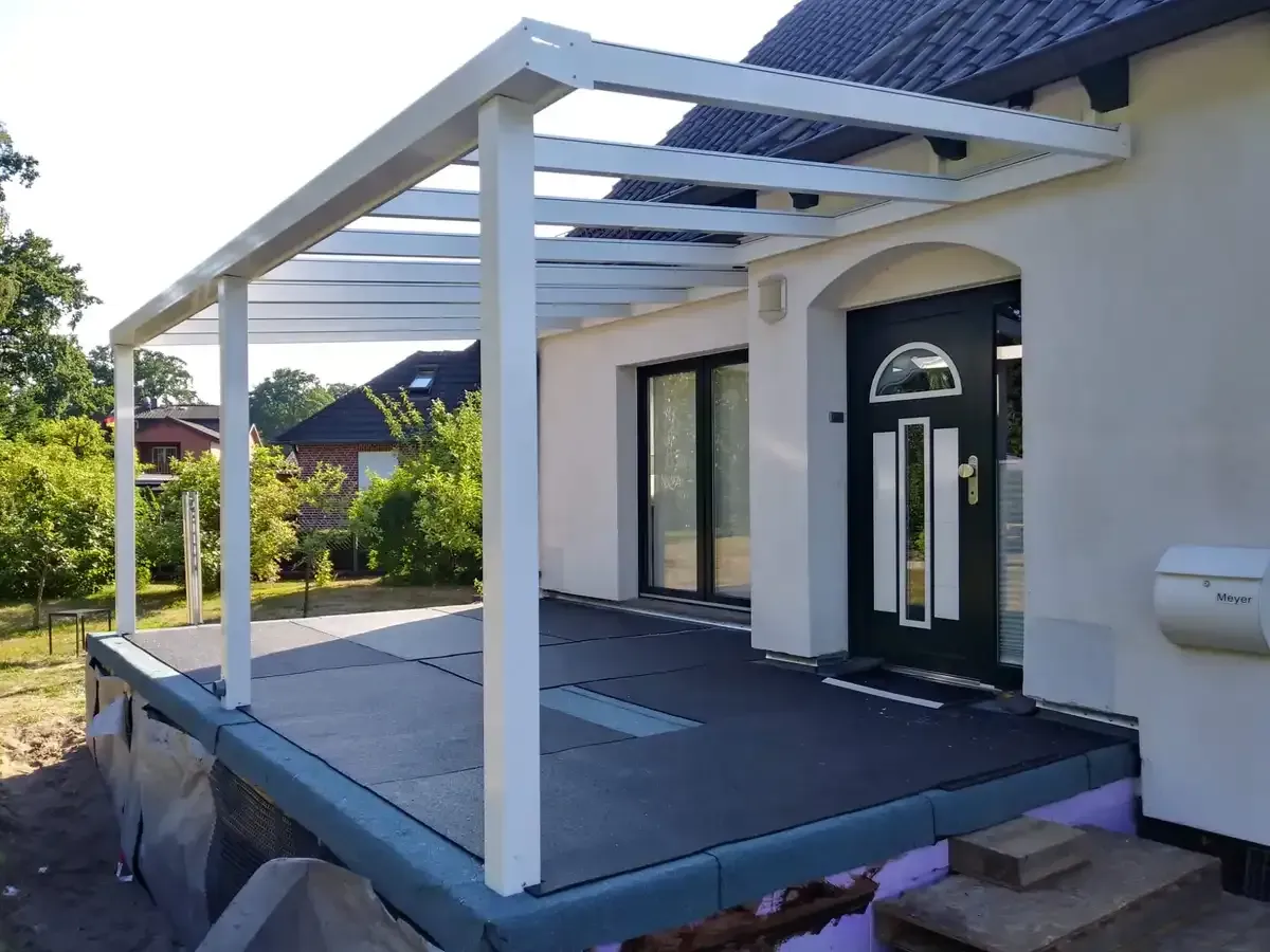 Ein weißes Haus mit einer schwarzen Tür und einer weißen Veranda.