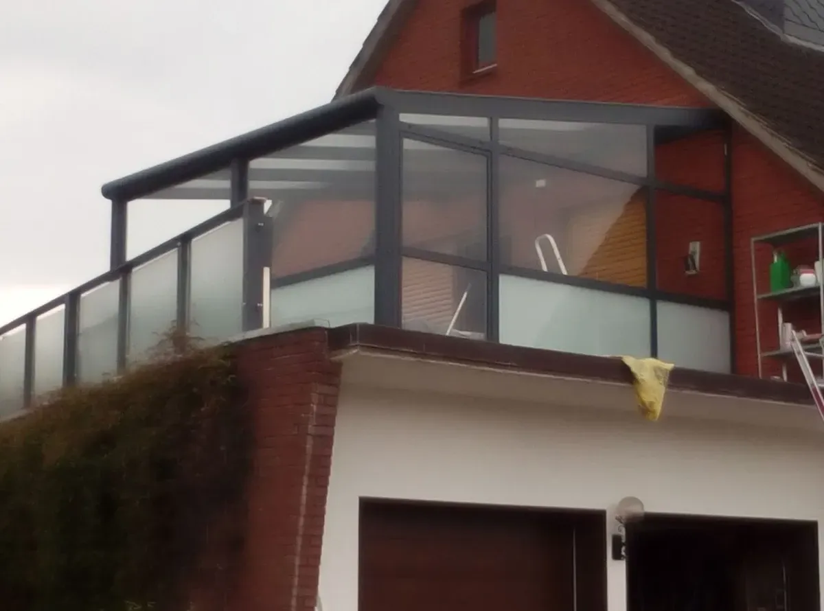 Ein Haus mit einem Balkon und einer Leiter an der Seite