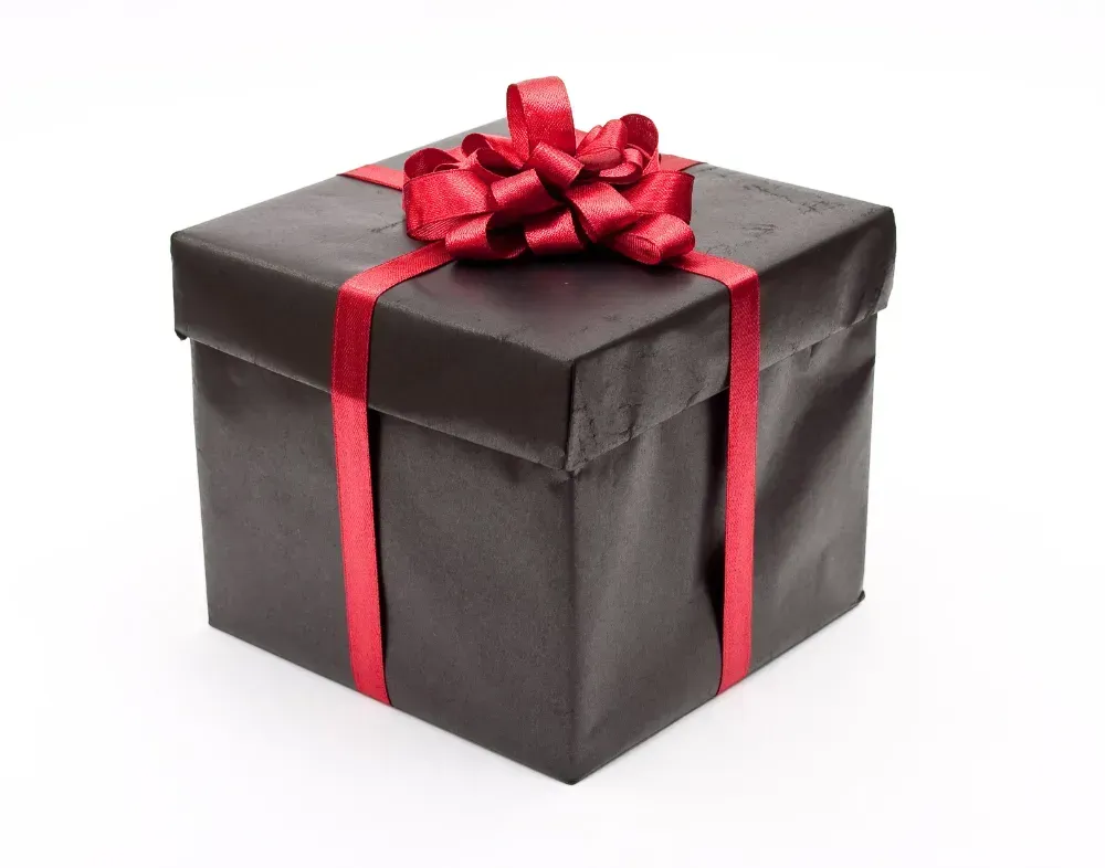 A black gift box with a red ribbon and bow