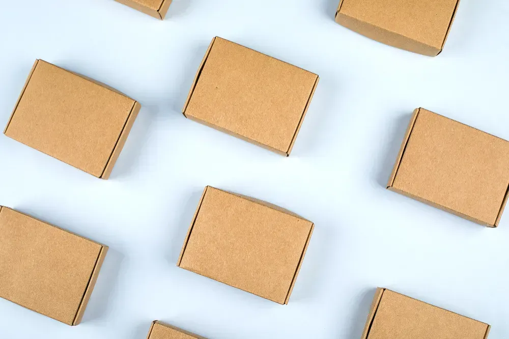 A group of cardboard boxes are lined up in a row on a white surface.
