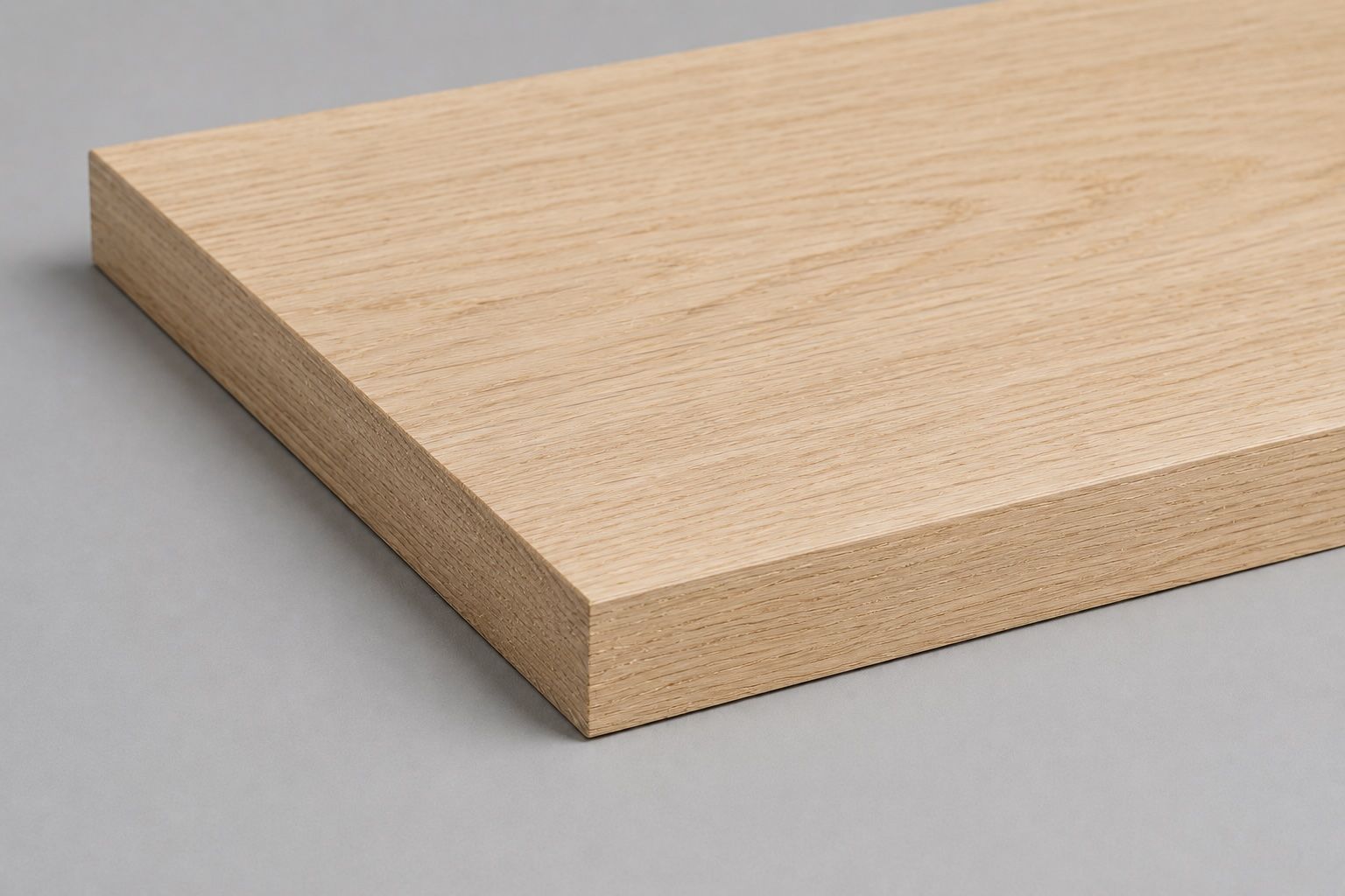 Helle Holzplatte mit glatten, abgeschrägten Kanten auf grauem Hintergrund